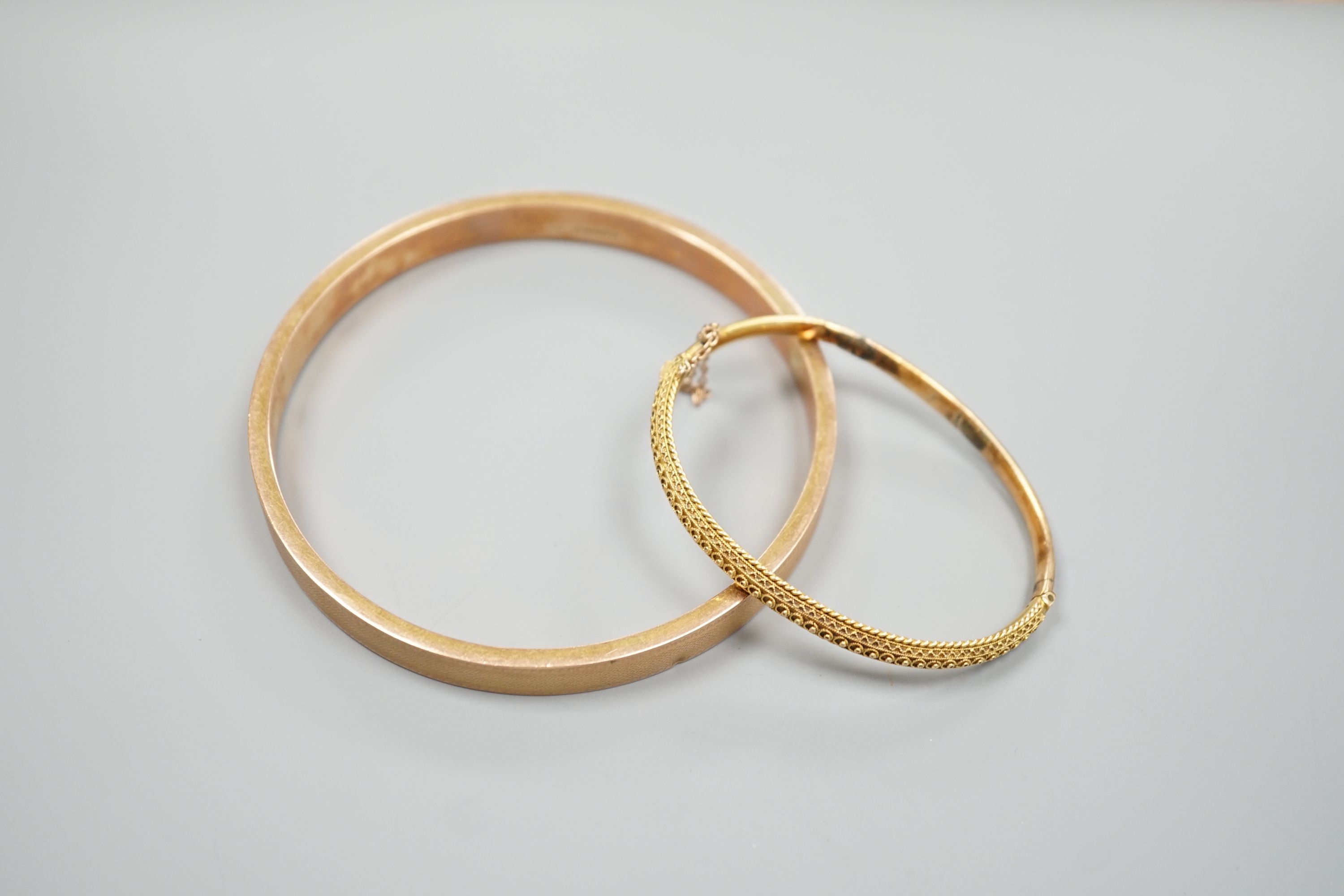 A 9ct gold bangle, 14.5 grams and a Victorian 15ct hinged bangle(a.f.), 7.8 grams.